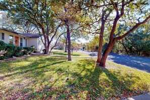A residential property with a lawn, trees, and a house. - Snowbird-Friendly Home w/ Enclosed Yard, Firepit, Central AC, & High-Speed WiFi (Fredericksburg)