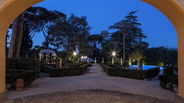 An arched pathway leading to a pool area with well-manicured hedges and trees, under a clear sky. - Vigne Franceschini Resort - villa with pool in the heart of Rome (Roma)