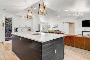 A modern kitchen with a central island, pendant lighting, and a chalkboard wall. - Spacious & elegant haven with huge yard, updated interior, AC, & fast WiFi (Horseshoe Bay)