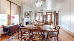 A dining room with a wooden table, chairs, and a chandelier. - Enchanting home with fireplace, full kitchen, patio, central AC, & washer/dryer (Fredericksburg)