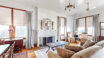 Ein Wohnzimmer mit Kamin, Essbereich und einer Couch.