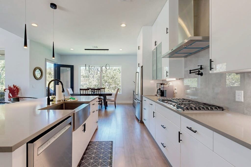 Una cocina moderna con una isla central, electrodomésticos integrados y un comedor con vistas.