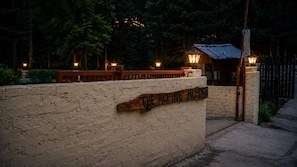 A brick wall with a wooden sign reading 'THE ALPINE HUT.'