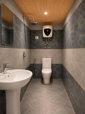 A modern bathroom with a wooden ceiling, a white sink, a toilet, and a showerhead.