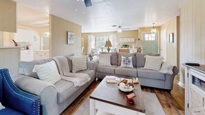 Ein Wohnzimmer mit zwei Sofas, einem Couchtisch und einer Chandelier.