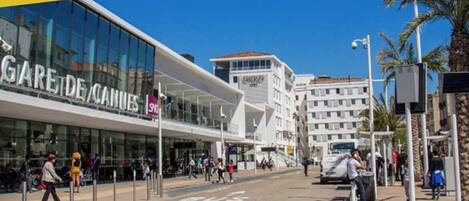 A modern building with a glass facade and a sign reading "GARE DE CANNES".