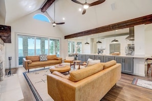 A spacious living area with a large sofa, a dining table, and a kitchen in the background.