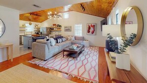 Un espacio habitable amplio con sofá, una mesita de centro y una cocina al fondo.