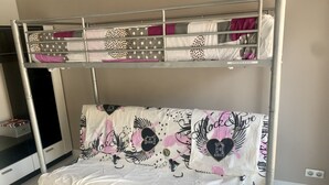 Ein Stockbett mit gemustertem Bettbezug und einem Zierkissen.