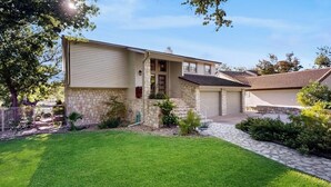 A single-story house with a stone facade, a front porch, and a well-maintained lawn. - Waterfront, dog-friendly home with lake views, private boat dock (Horseshoe Bay)