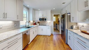 A modern kitchen with white cabinets, a microwave, and a refrigerator. - Waterfront, dog-friendly home with lake views, private boat dock (Horseshoe Bay)