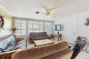 A living room with a ceiling fan, a TV, and a sofa. - Lakefront home with dock, patio, kayaks, & central AC - dog-friendly (Kingsland)