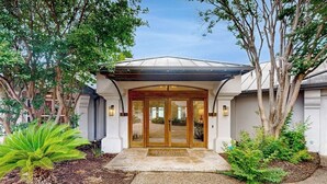A house with a covered entrance, a stone pathway, and a well-maintained garden. - Luxe lakefront retreat with private pool, spa, lakeside terrace, gourmet kitchen (Horseshoe Bay)