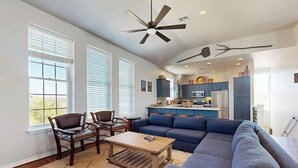 A living room with a sofa, chairs, a coffee table, and a ceiling fan. - Spicewood Lake Retreat | Pool + Shuffleboard (Spicewood)