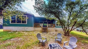 A house with a porch, outdoor seating, and a tree. - Cozy Lago Vista home with Private Pool table, mile from the stunning Lake Travis (Lago Vista)