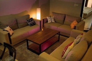 Un salon avec deux canapés, une table basse et une lampe.