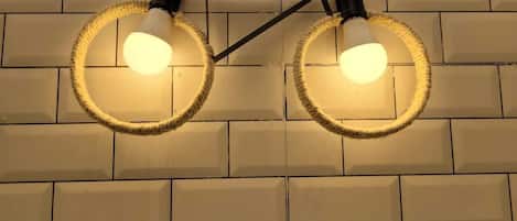 A wall-mounted light fixture with two bulbs, connected by a black metal frame.