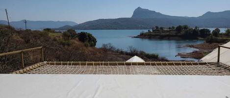 A staircase leading to a white platform overlooking a lake with mountains in the background.