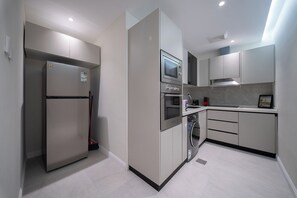 Eine moderne Küche mit Kühlschrank, Backofen, Mikrowelle und Spüle.