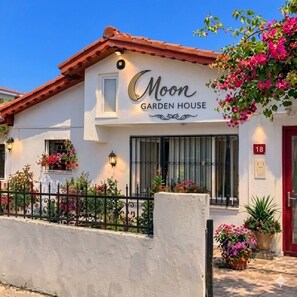 A white building with a sign reading 'Moon Garden House.'
