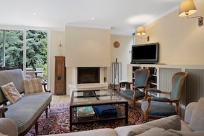 A living room with a fireplace, a television, and comfortable seating.