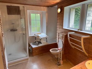 A compact wooden bathroom with a glass shower enclosure, a toilet, and a window providing natural light. - Holiday Home 'Le Petit Moulin Du Pré Saint-Gorgon' with Private Terrace, Private Garden and Wi-Fi (Feuguerolles-Bully)