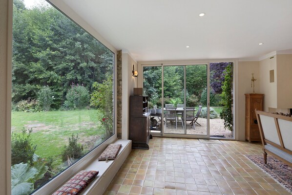 A spacious room with a large sliding glass door leading to an outdoor patio area.