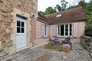 A stone building with a white door and windows with shutters. - Holiday Home 'Le Petit Moulin Du Pré Saint-Gorgon' with Private Terrace, Private Garden and Wi-Fi (Feuguerolles-Bully)