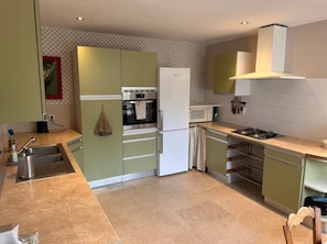 A compact kitchen with a built-in oven, microwave, and gas stove.