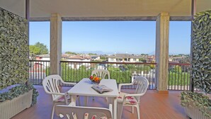 A balcony with a table, chairs, a fruit bowl, and a magazine. - Apollo 19 by Wonderful Italy (Sirmione)