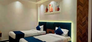 Habitación de hotel con dos camas, un muro decorativo de madera y una obra de arte colgada en la pared.