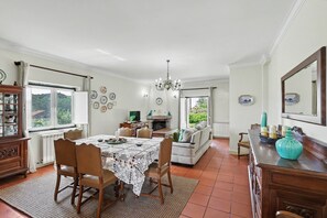 A dining area with a table set for four, a sofa, and a fireplace.