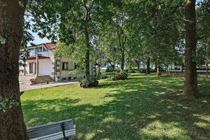 A residential property with a well-maintained lawn, a front porch, and a staircase leading to the entrance.