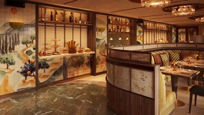 Un restaurant à la décoration traditionnelle, avec un comptoir où sont présentés divers plats et une salle à manger avec des tables et des chaises.