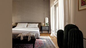 Un dormitorio con cama, mesita de noche y un gran ventanal con cortinas.