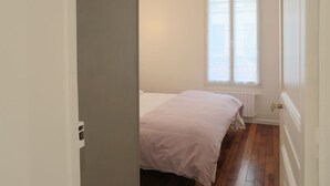 Ein Zimmer mit Bett, Fenster und Heizkörper.