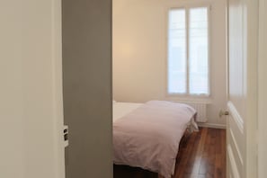 A room with a bed, a window, and a radiator. - Very nice 2-bed flat with a private garden in the 16th. Perfect for families (Paris)