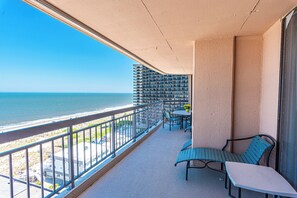 A balcony with a view of the ocean, a table, and two chairs. - Beautifully Renovated 2 Bedroom Ocean Front Condo! Fountainhead Towers 1201 (Ocean City)