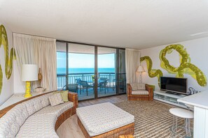 A balcony with a view of the sea, a sofa, a TV, and a dining area. - Beautifully Renovated 2 Bedroom Ocean Front Condo! Fountainhead Towers 1201 (Ocean City)