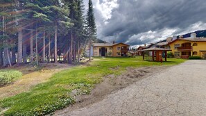 Zona residencial con casas, una calle pavimentada y un área verde con árboles.