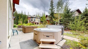Jacuzzi y terraza de madera en un barrio residencial con casas y árboles.