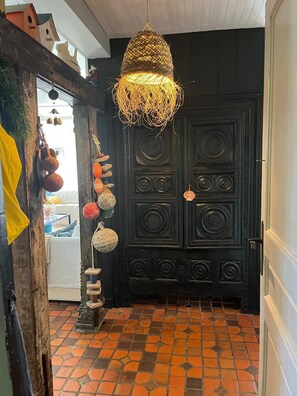 A room with a black door, a hanging light fixture, and a tiled floor. - Charming property, family home, panoramic ocean view, large, quiet garden (Plouarzel)
