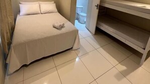 Une chambre à coucher avec un lit, un banc et une porte donnant sur une autre pièce.