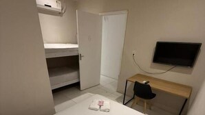 Une chambre d’hôtel équipée d’un lit, d’un bureau, d’une chaise, d’une télévision et d’une armoire.