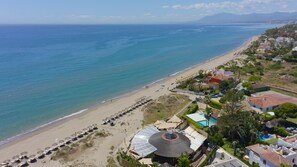 Un hôtel situé sur la côte, avec accès à la plage, une piscine et vue sur la mer.