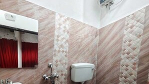 A bathroom with a toilet, sink, and shower head. - Nilay Guest House (Kolkata)