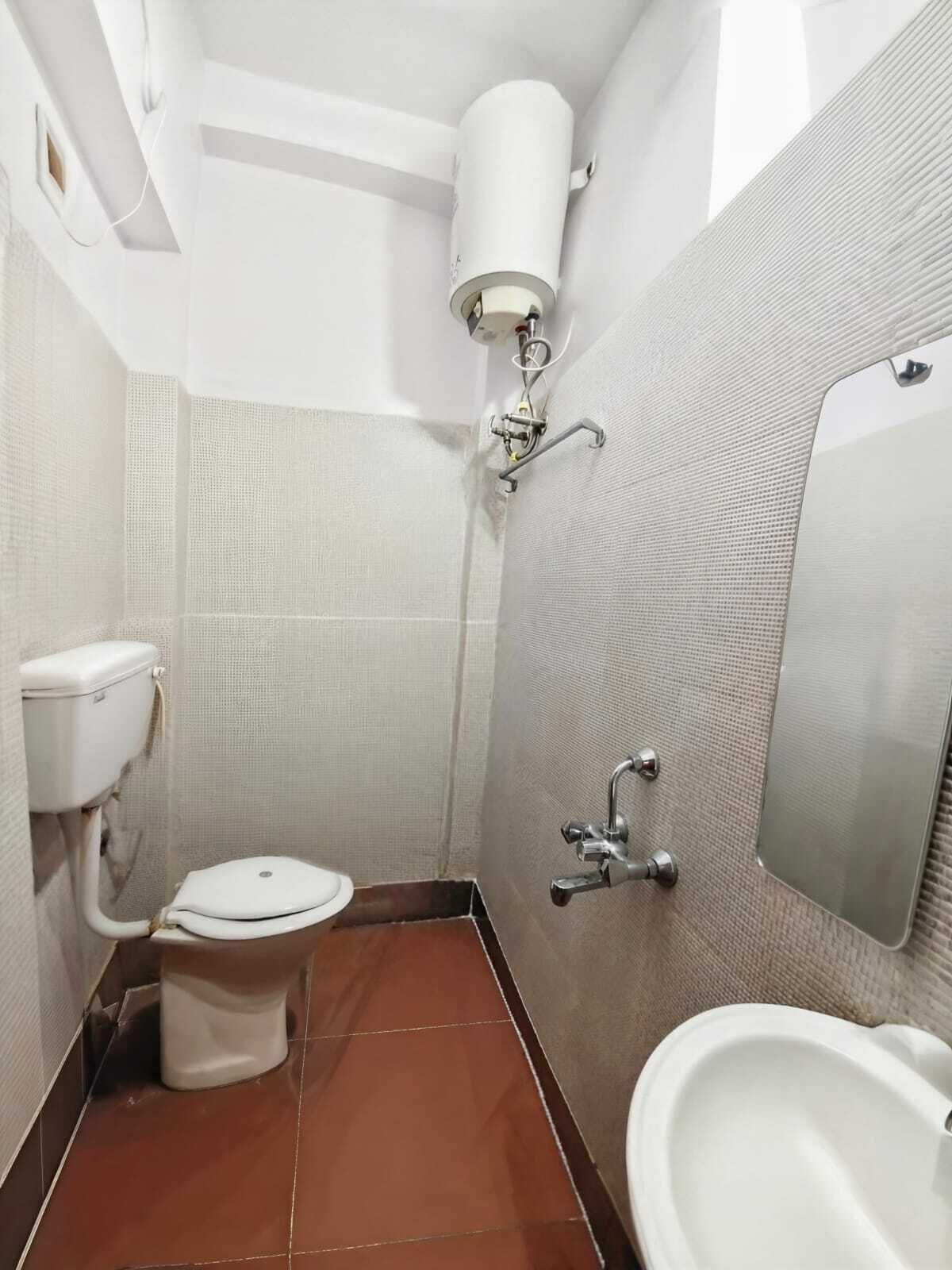 Un baño pequeño con inodoro, lavabo y espejo.