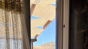 Eine Küche mit Fenster, Spüle und Blick auf eine Hügelkette.