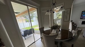 A dining area with a round table, chairs, and a chandelier. - Beautiful 3-bedroom House in New Tampa (Tampa)