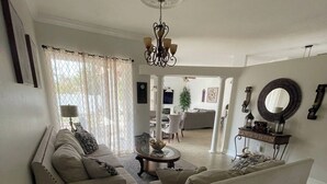 A living room with two sofas, a coffee table, and a chandelier. - Beautiful 3-bedroom House in New Tampa (Tampa)